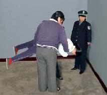 Image for article Les gardiens de prison tiennent un homme en position inversée et lui cognent la tête contre le sol pour le faire taire