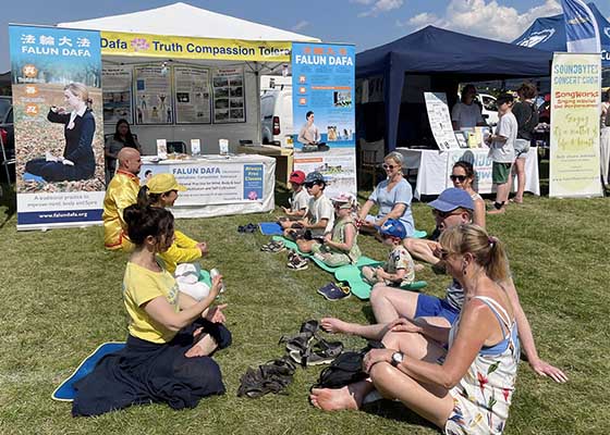 Image for article Les gens apprennent les exercices de Falun Dafa dans le cadre du festival de l’Ashtead Village Day en Angleterre