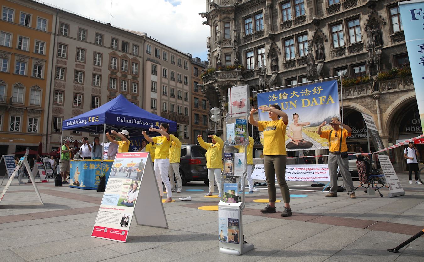 Image for article Allemagne : Une habitante de Munich présente une fleur aux pratiquants de Falun Gong durant leurs activités de sensibilisation à la persécution