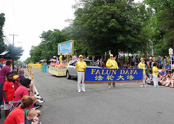 Image for article Washington DC, États-Unis : Des spectateurs s’informent sur le Falun Dafa auprès de pratiquants lors du défilé du jour du Souvenir