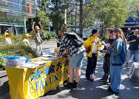 Image for article Des personnes encouragent les pratiquants de Falun Dafa lors d’une activité organisée au World Trade Center d’Amsterdam